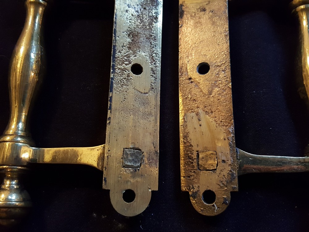 A pair of cast Victorian brass sash lifts featuring turned baluster handles with finials attached to flat mounting plates with screw holes. View IV