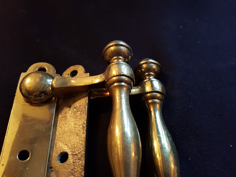 A pair of cast Victorian brass sash lifts featuring turned baluster handles with finials attached to flat mounting plates with screw holes. View V