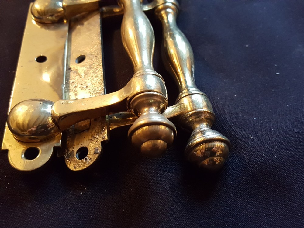 A pair of cast Victorian brass sash lifts featuring turned baluster handles with finials attached to flat mounting plates with screw holes. View VI