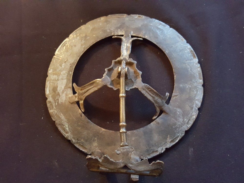 A circular Victorian brass kettle stand trivet featuring a fluted rim design and a central three-spoke motif. View V