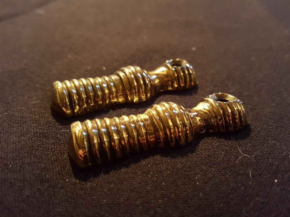 A pair of turned, polished brass keyhole escutcheons featuring a ribbed beehive design with a single mounting hole at the top. View IV