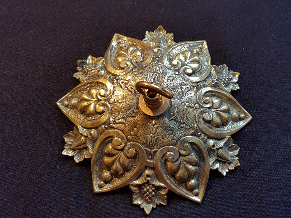 An ornate circular Victorian cast brass ceiling rose featuring relief foliage decoration and a central hanging hook. View IV