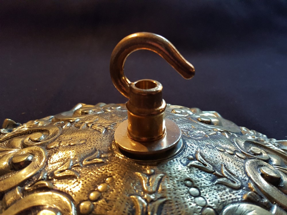 An ornate circular Victorian cast brass ceiling rose featuring relief foliage decoration and a central hanging hook. View V