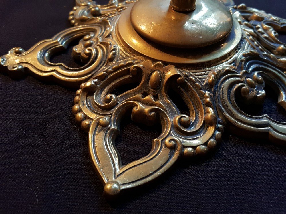 A Victorian cast brass ceiling rose featuring a central metal hook surrounded by openwork scrollwork and a starburst edge profile. View II