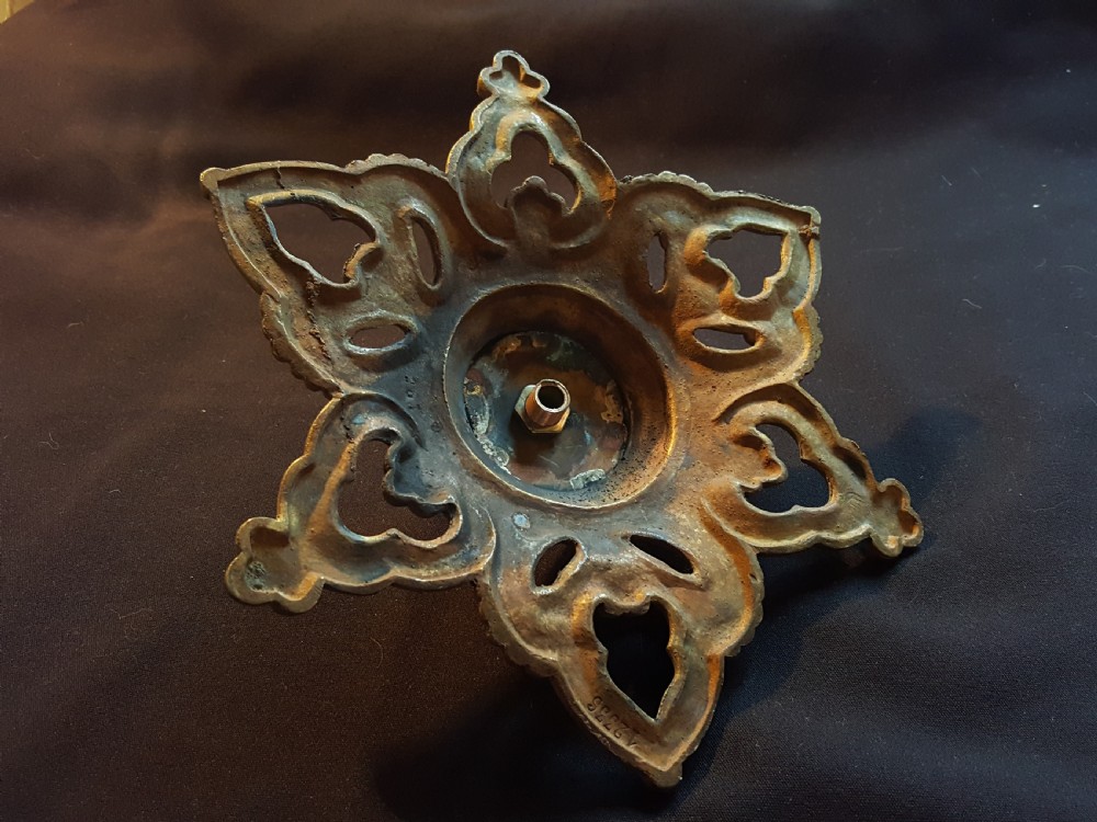 A Victorian cast brass ceiling rose featuring a central metal hook surrounded by openwork scrollwork and a starburst edge profile. View VI