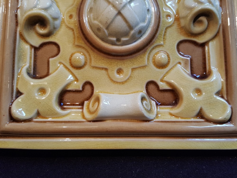 A set of six Victorian square earthenware tiles featuring high-relief moulded scrollwork and central cabochons in ochre and brown glazes. View III