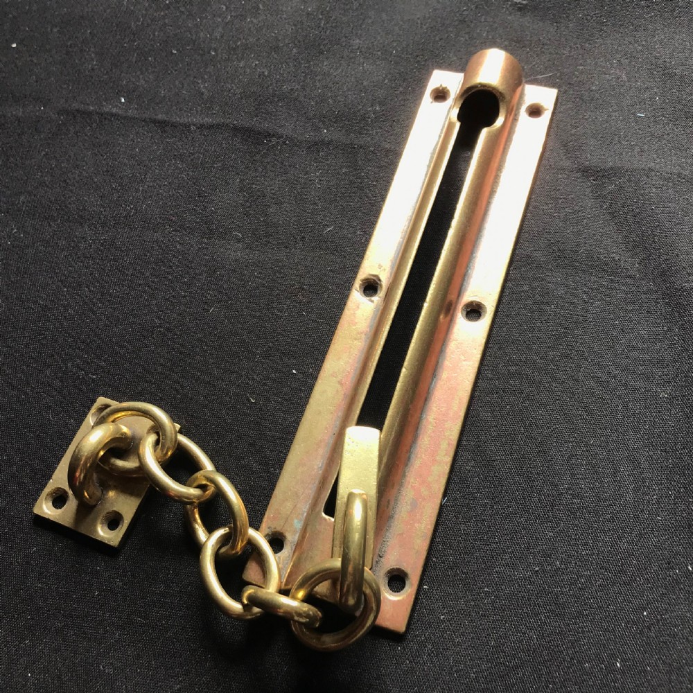 A solid brass Victorian night door chain featuring a slotted slider backplate, a small mounting plate, and connecting oval chain links. View II