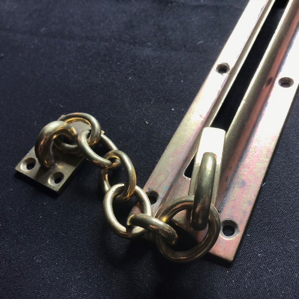 A solid brass Victorian night door chain featuring a slotted slider backplate, a small mounting plate, and connecting oval chain links. View III