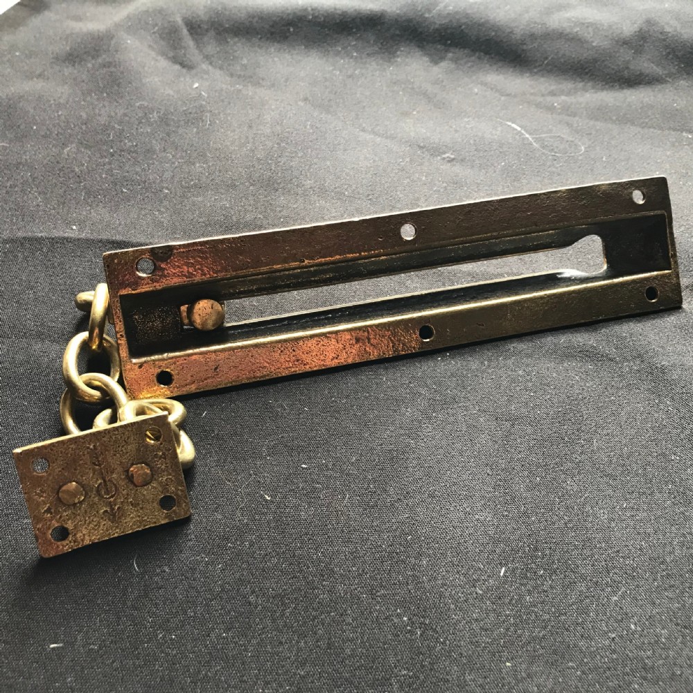 A solid brass Victorian night door chain featuring a slotted slider backplate, a small mounting plate, and connecting oval chain links. View IV