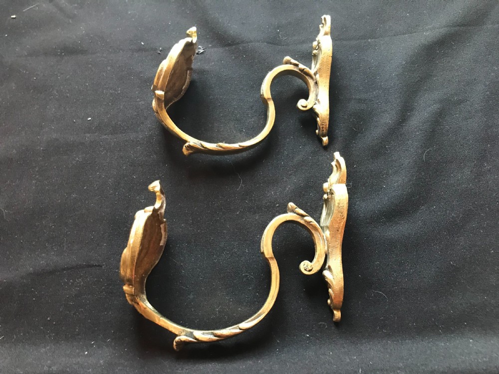 A pair of heavy cast brass curtain tiebacks featuring sculpted acanthus leaf and C-scroll motifs. View IV