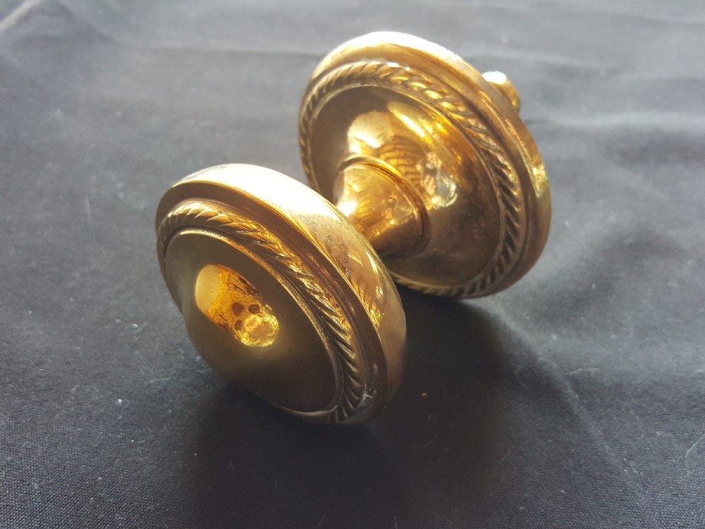 A solid brass Regency centre door knob featuring a circular domed face with a rope-twist border and matching backplate. View II
