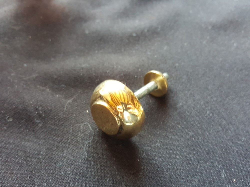 A polished brass door knocker shaped as a stylised dolphin mounted on a Maltese cross backplate alongside a separate brass striker button. View V