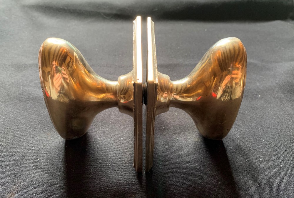 A pair of antique cast bronze oval door knobs mounted on square backplates with beaded borders. View VI