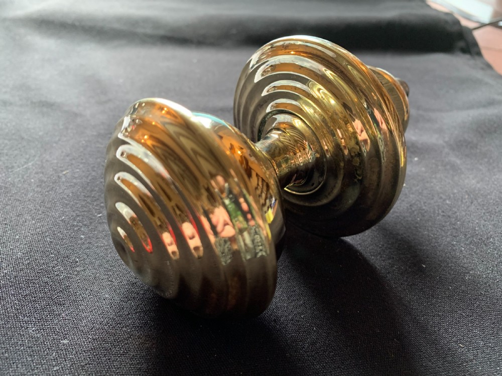 A solid brass Georgian style centre door knob with concentric reeded circular profiling mounted on a stepped circular rose.