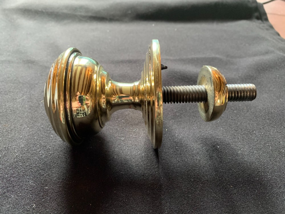 A solid brass Georgian style centre door knob with concentric reeded circular profiling mounted on a stepped circular rose. View III