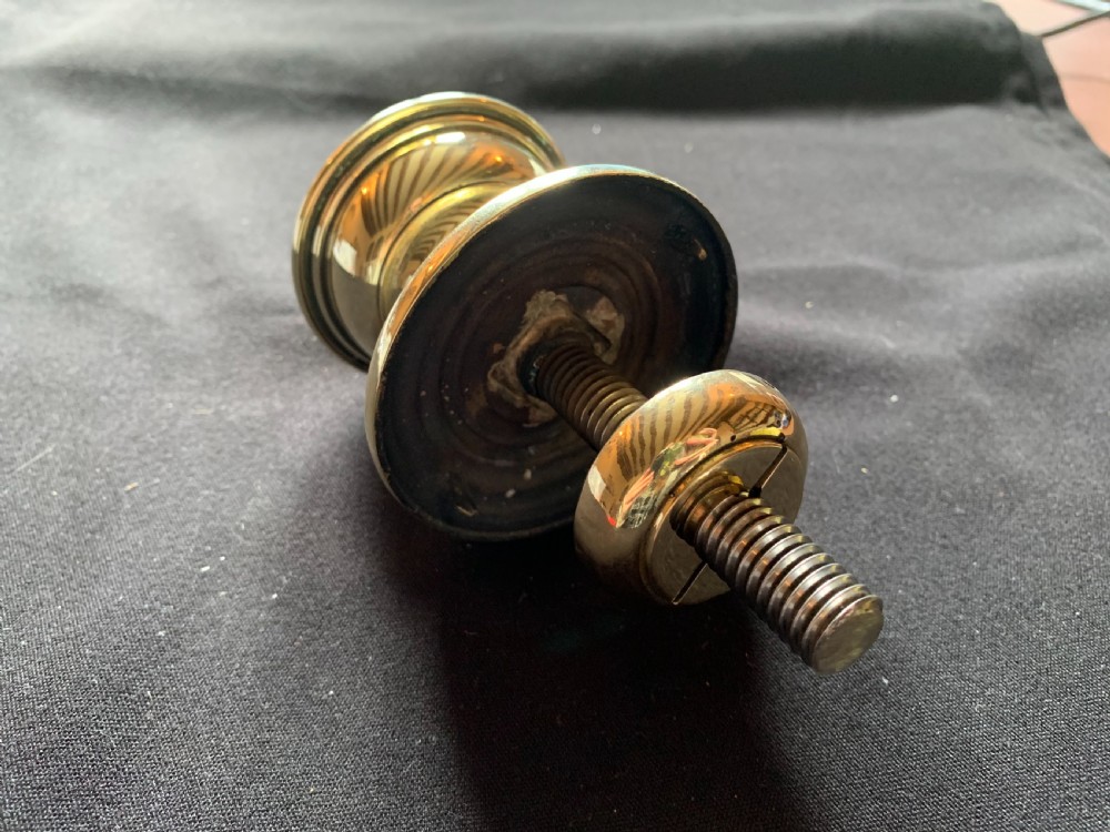 A solid brass Georgian style centre door knob with concentric reeded circular profiling mounted on a stepped circular rose. View IV