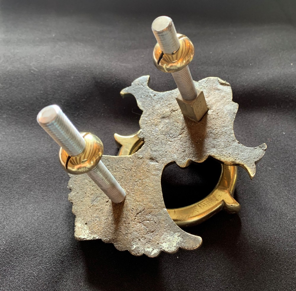 A polished solid brass Victorian door knocker featuring a heavy circular ring hinged above a fluted fan backplate. View VI