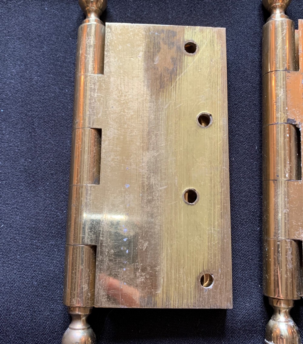 A pair of solid brass Victorian door hinges featuring decorative turned finials at both ends of each hinge pin. View II