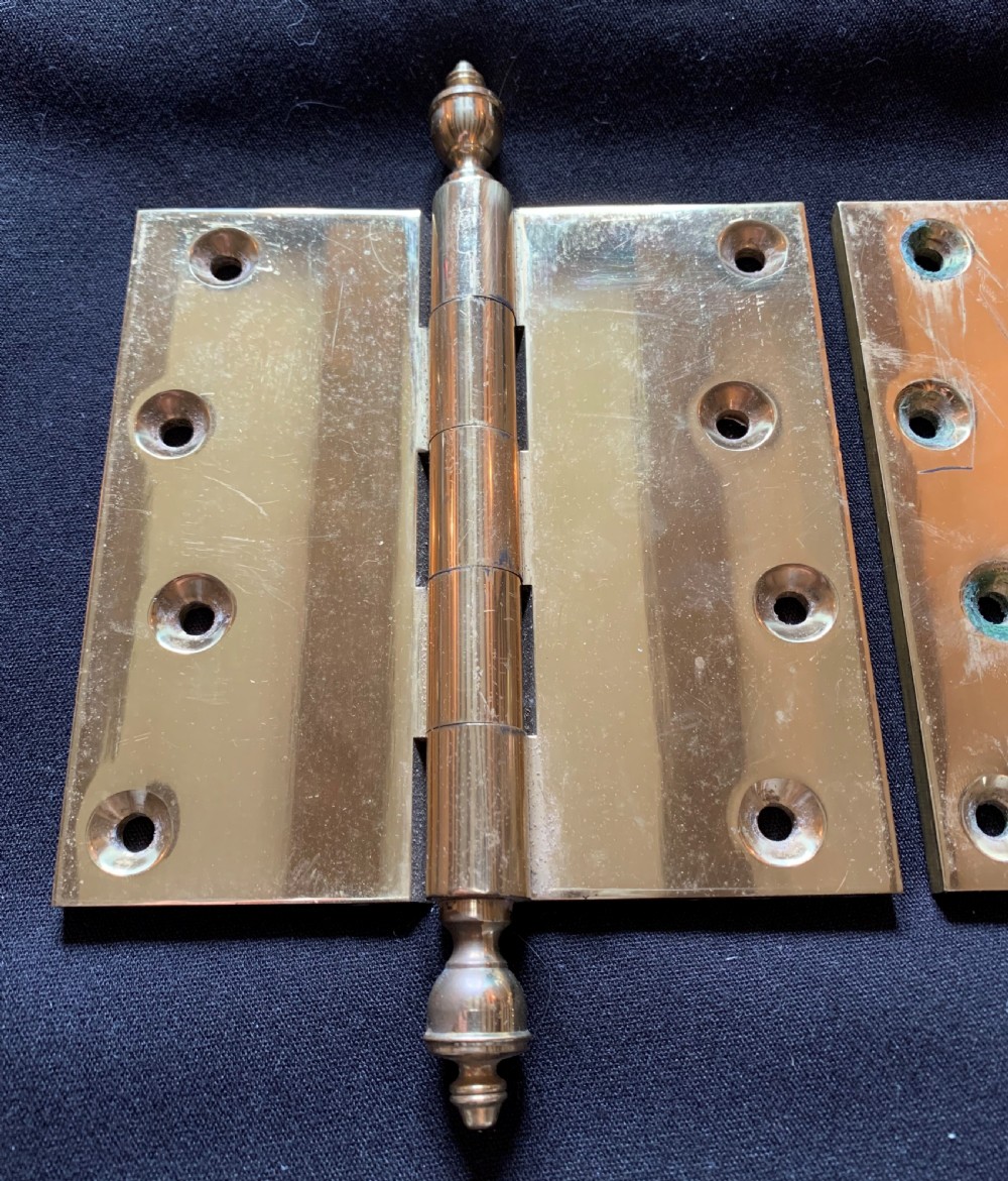 A pair of solid brass Victorian door hinges featuring decorative turned finials at both ends of each hinge pin. View IV