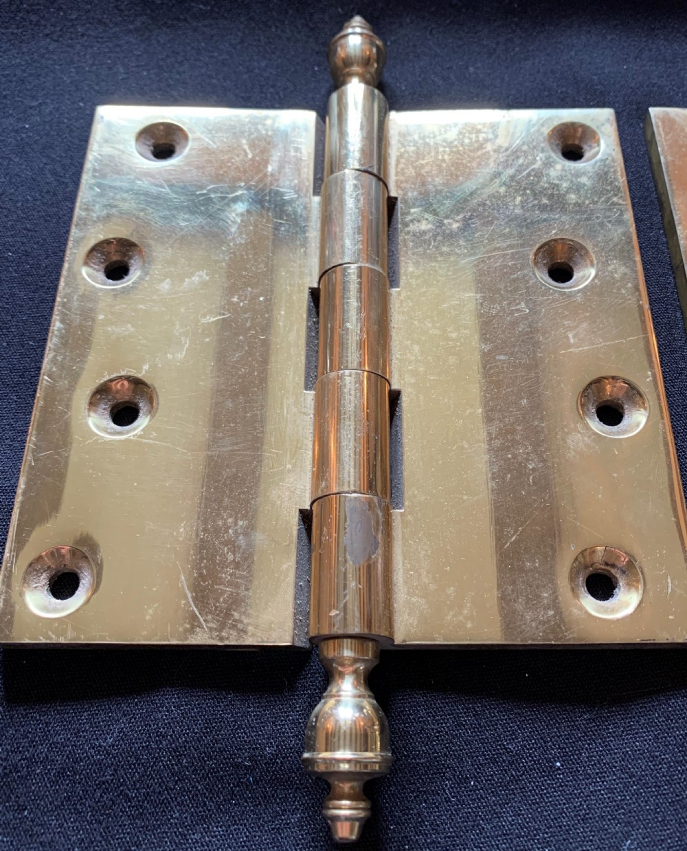 A pair of solid brass Victorian butt door hinges featuring turned urn finials at the top and bottom of each hinge pin. View VI