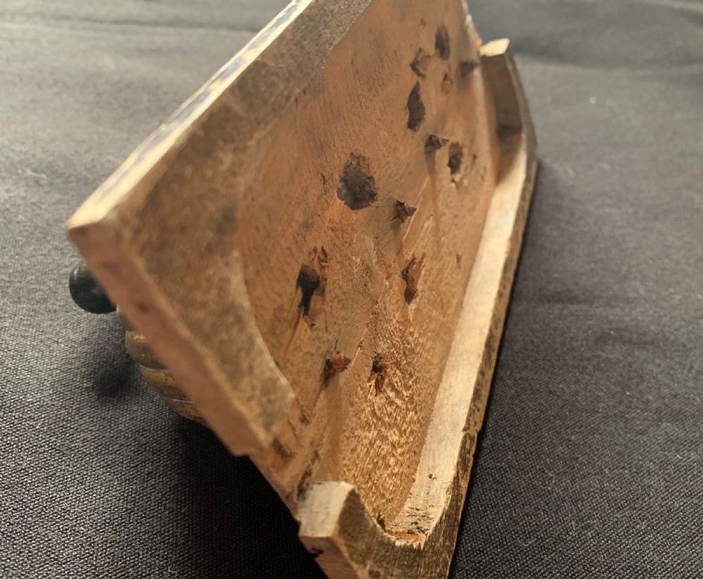 An antique Victorian double lever light switch featuring fluted brass domes on white porcelain bases, connected by a dark wooden lever bar on a timber backplate. View VI