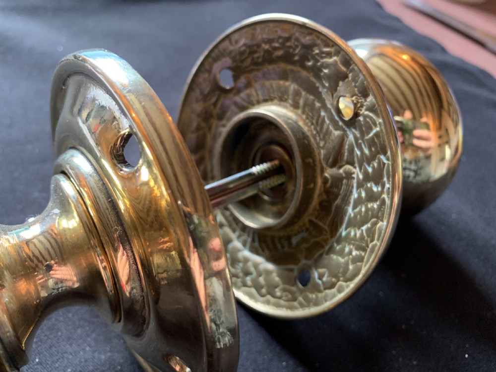 A pair of polished brass Georgian mortice door knobs complete with round rose plates and a connecting central steel spindle. View IV