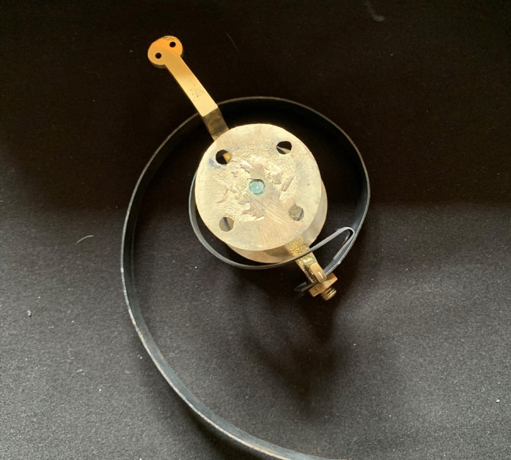 A restored Victorian mechanical servants bell featuring a polished brass bell suspended from a curved black steel spiral spring. View VI