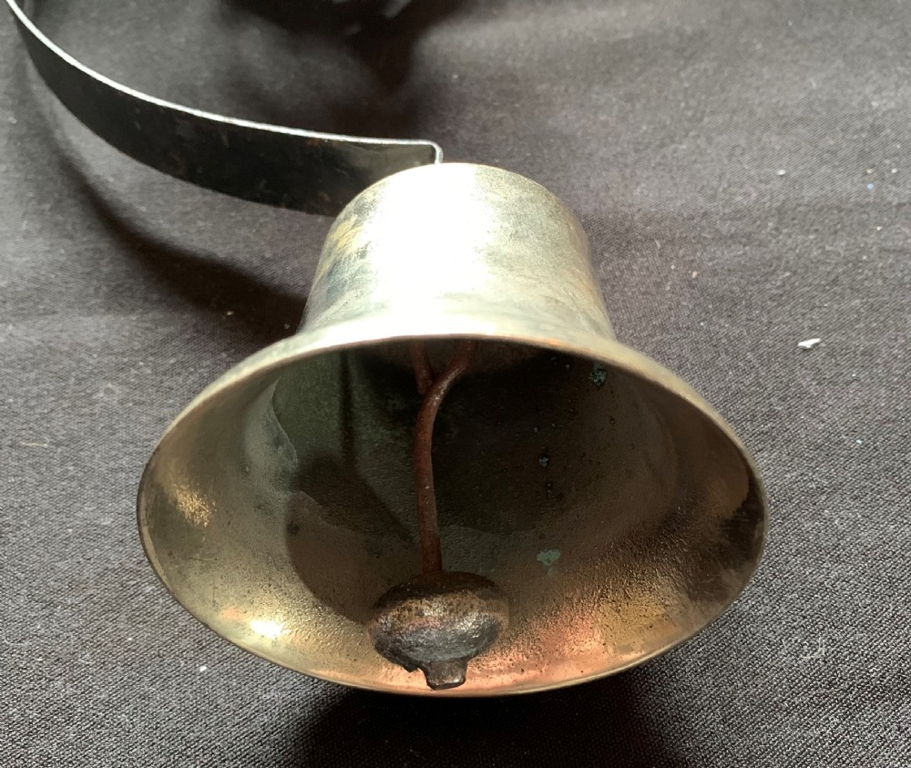 A restored Victorian mechanical servants bell featuring a polished brass bell suspended from a curved black steel spiral spring. View VII