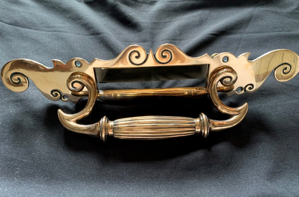 A polished Victorian bronze letter plate featuring an integrated scroll door pull handle and engraved scrollwork details.