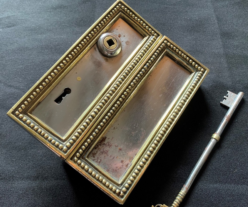 A rectangular French Victorian brass and polished steel rim lock with a beaded edge frame and an ornate matching key. View II