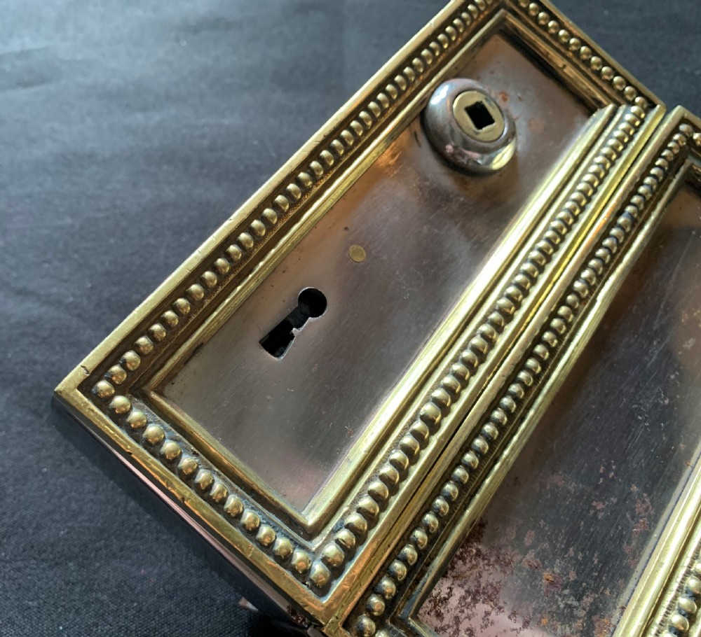 A rectangular French Victorian brass and polished steel rim lock with a beaded edge frame and an ornate matching key. View III