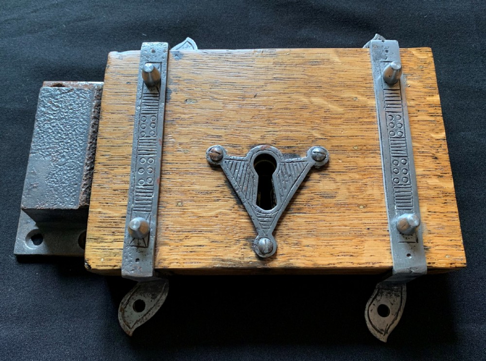 An antique Victorian surface-mounted wooden rim lock crafted from oak with decorative steel straps, accompanied by a steel keep and an original iron key. View II