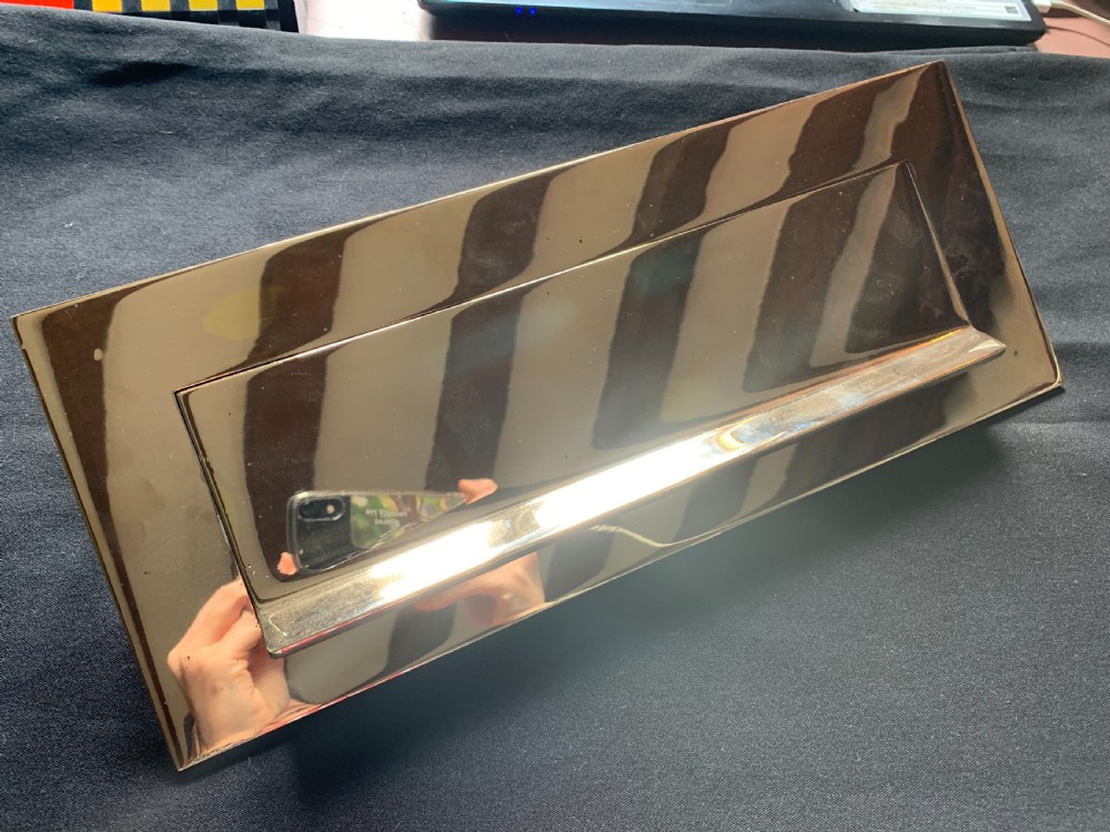 A polished brass rectangular Victorian letter box plate featuring a hinged central flap with an ergonomic lower lip.