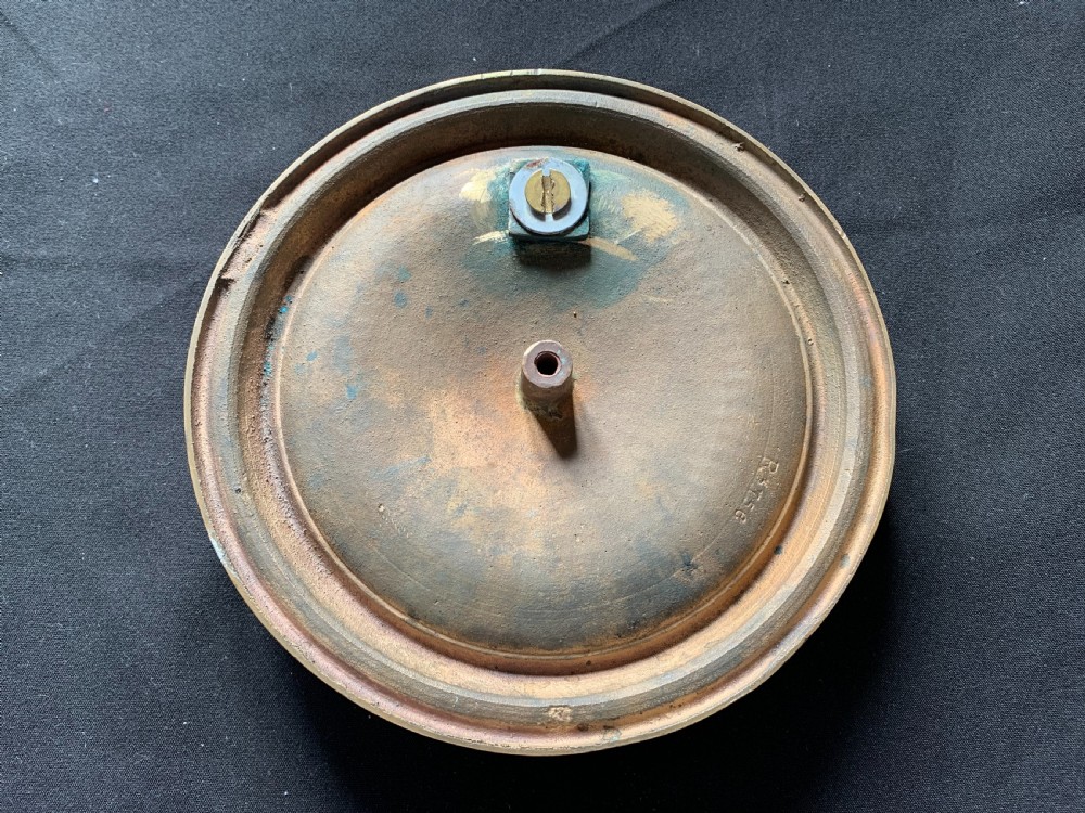 A circular polished brass Georgian door knocker with a heavy ring handle mounted on a moulded circular backplate. View V