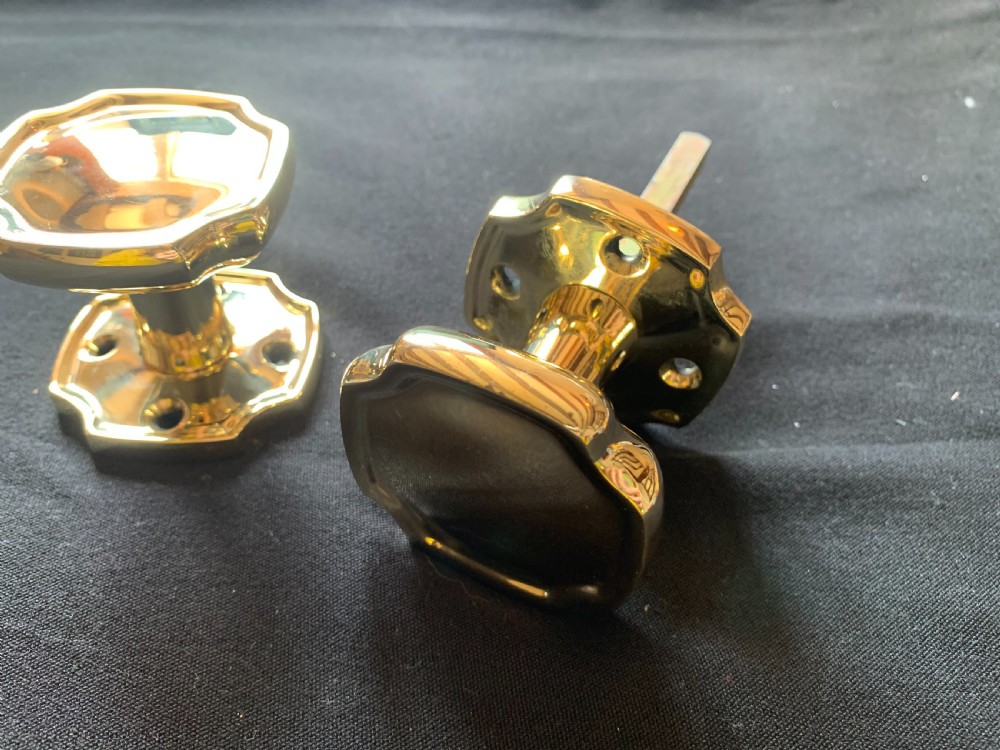 A pair of polished brass Victorian door knobs with square rose plates and a connecting spindle. View III