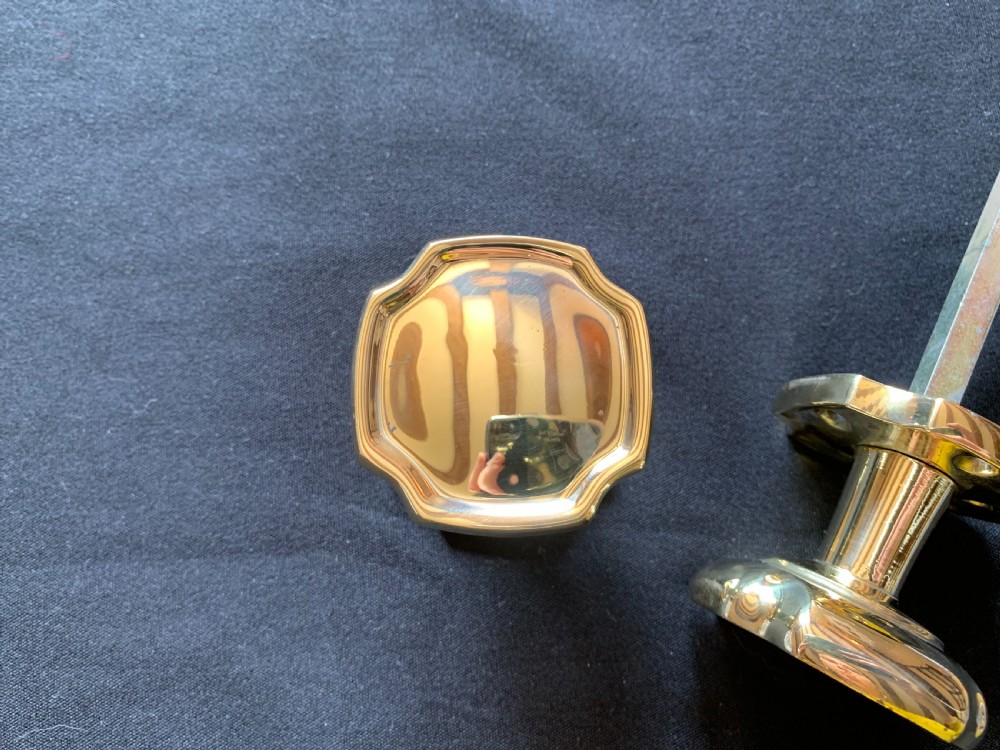 A pair of polished brass Victorian door knobs with square rose plates and a connecting spindle. View IV