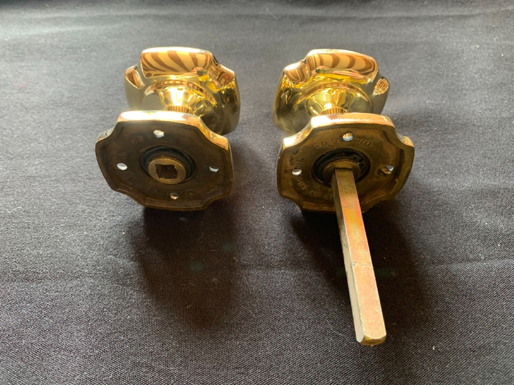 A pair of polished brass Victorian door knobs with square rose plates and a connecting spindle. View VI