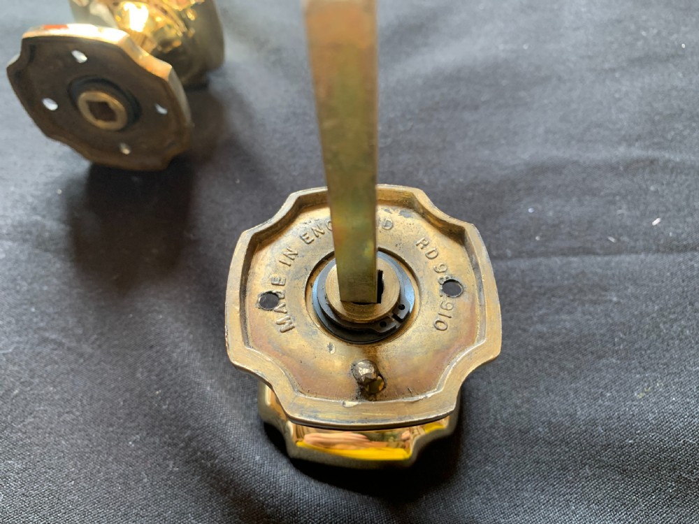 A pair of polished brass Victorian door knobs with square rose plates and a connecting spindle. View VII