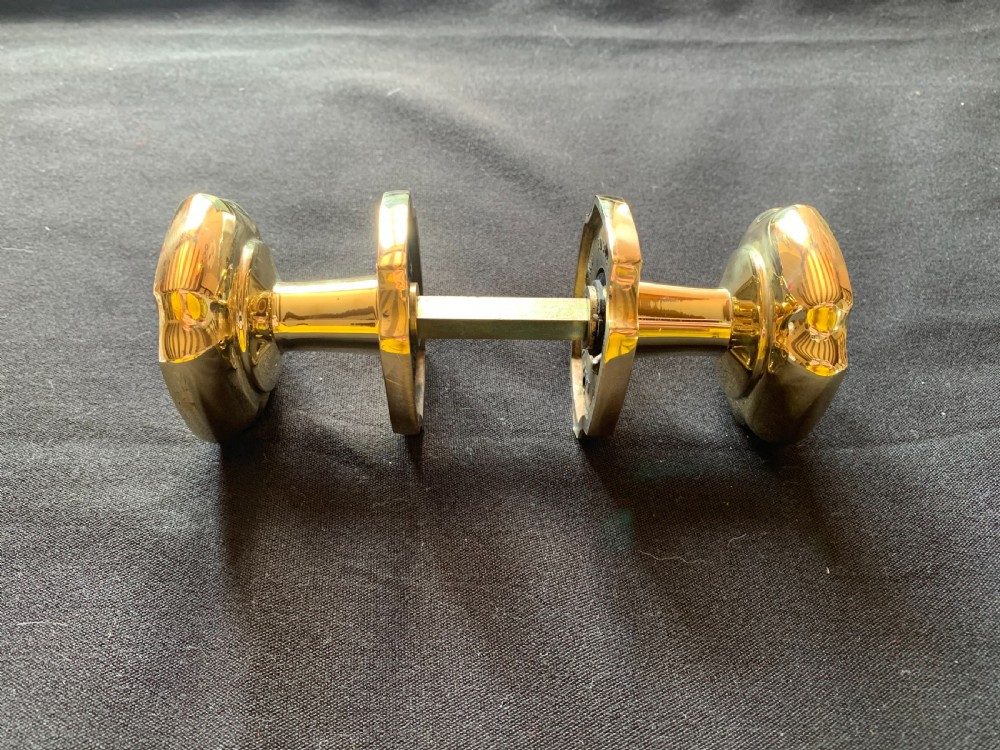 A pair of polished brass Victorian door knobs with square rose plates and a connecting spindle. View VIII