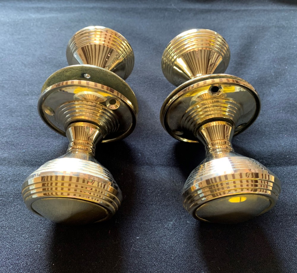 Two pairs of polished brass Victorian beehive door knobs with reeded bodies and circular rose plates. View V
