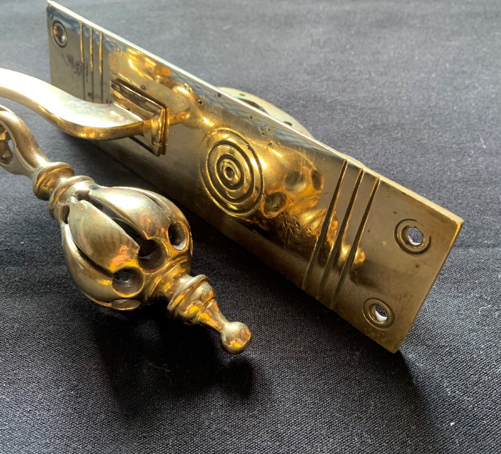 A brass Georgian mechanical doorbell pull featuring a rectangular backplate engraved with concentric circles and a bulbous drop handle. View III