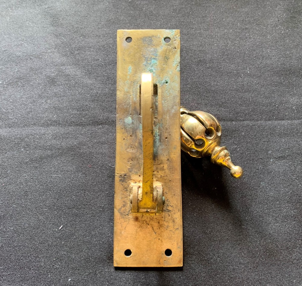 A brass Georgian mechanical doorbell pull featuring a rectangular backplate engraved with concentric circles and a bulbous drop handle. View VI