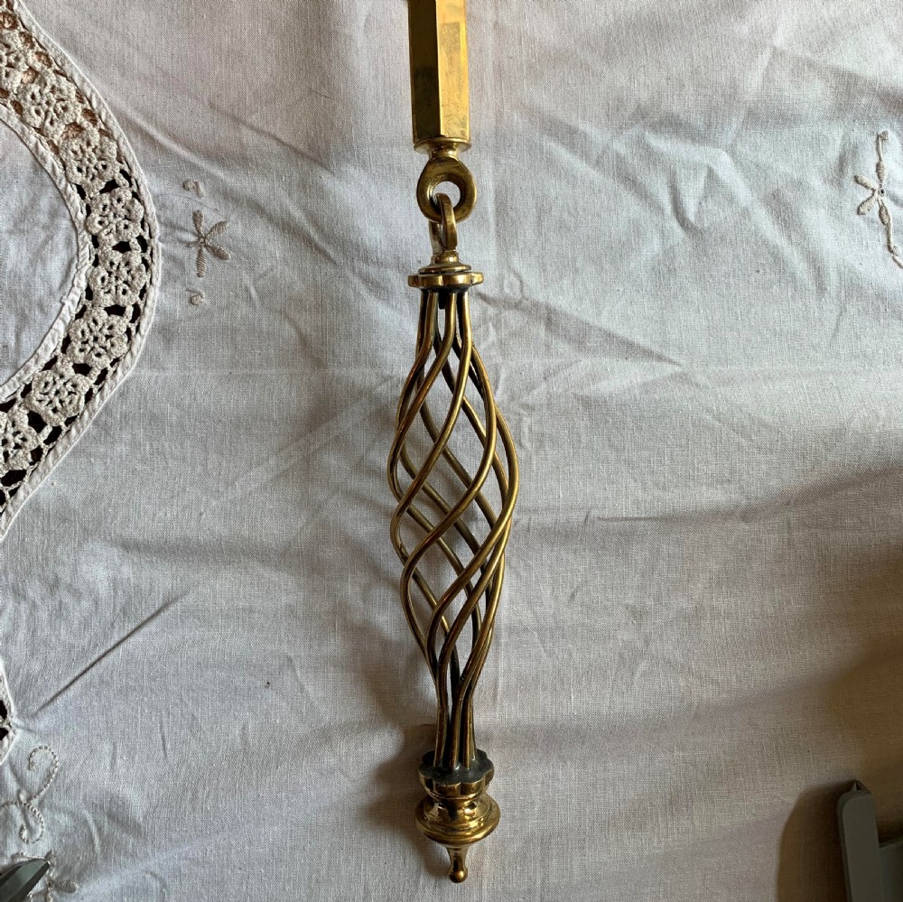 A restored Victorian mechanical door bell pull in polished brass featuring a spiral cage handle and twin decorative mounting brackets. View III