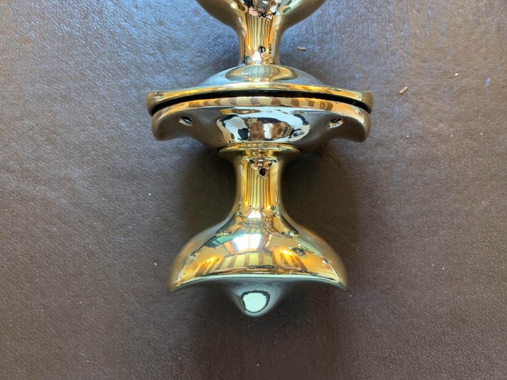 A pair of polished brass oval door knobs mounted on a spindle assembly with oval backplates. View IV
