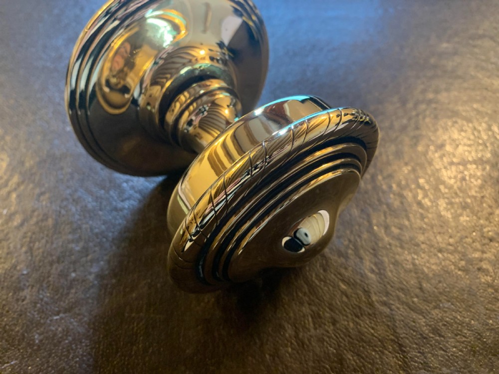 A polished brass centre door knob featuring a stepped circular backplate and a rope-twist detailed edge. View II
