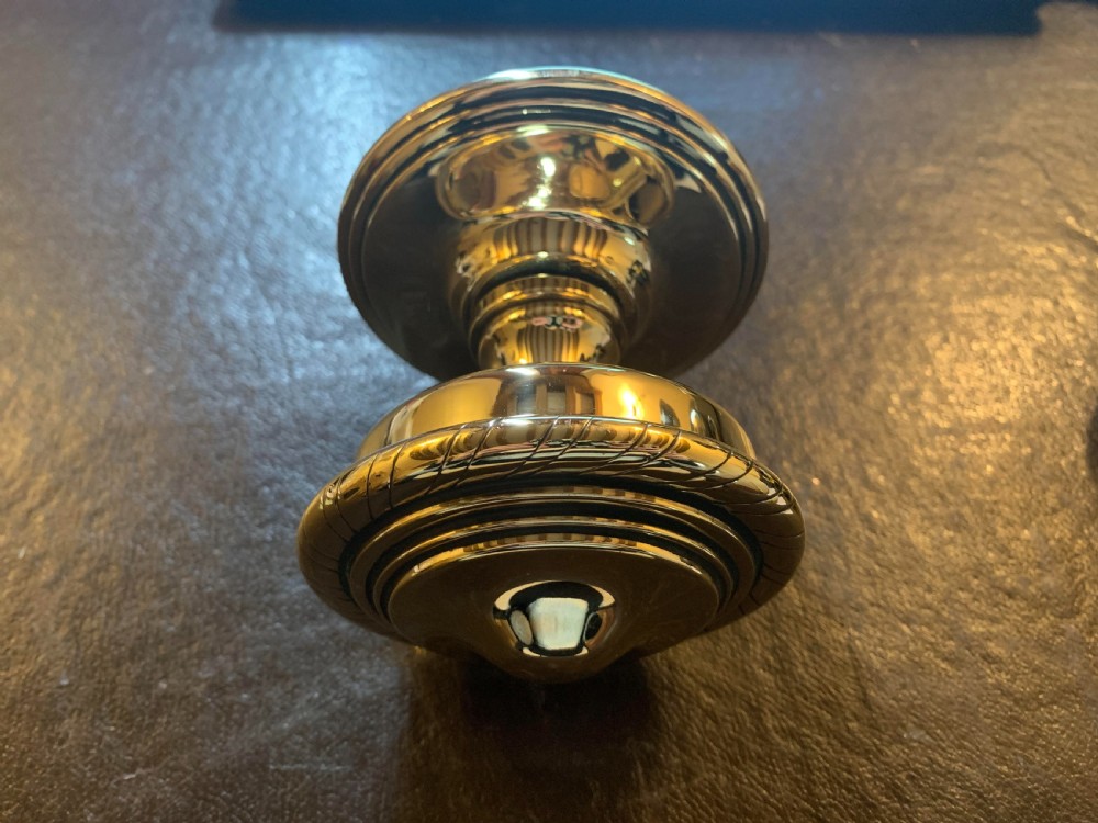 A polished brass centre door knob featuring a stepped circular backplate and a rope-twist detailed edge. View III