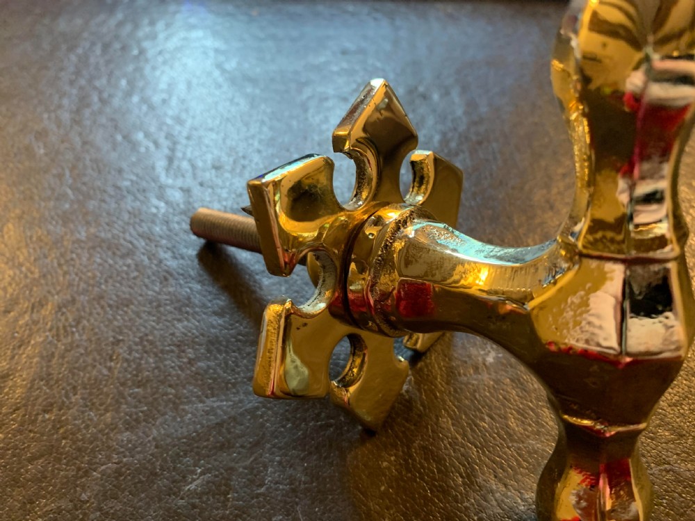 A polished brass Victorian centre door knob featuring a pointed T-bar handle and an ornate star-shaped rosette backplate with a threaded mounting bolt. View III