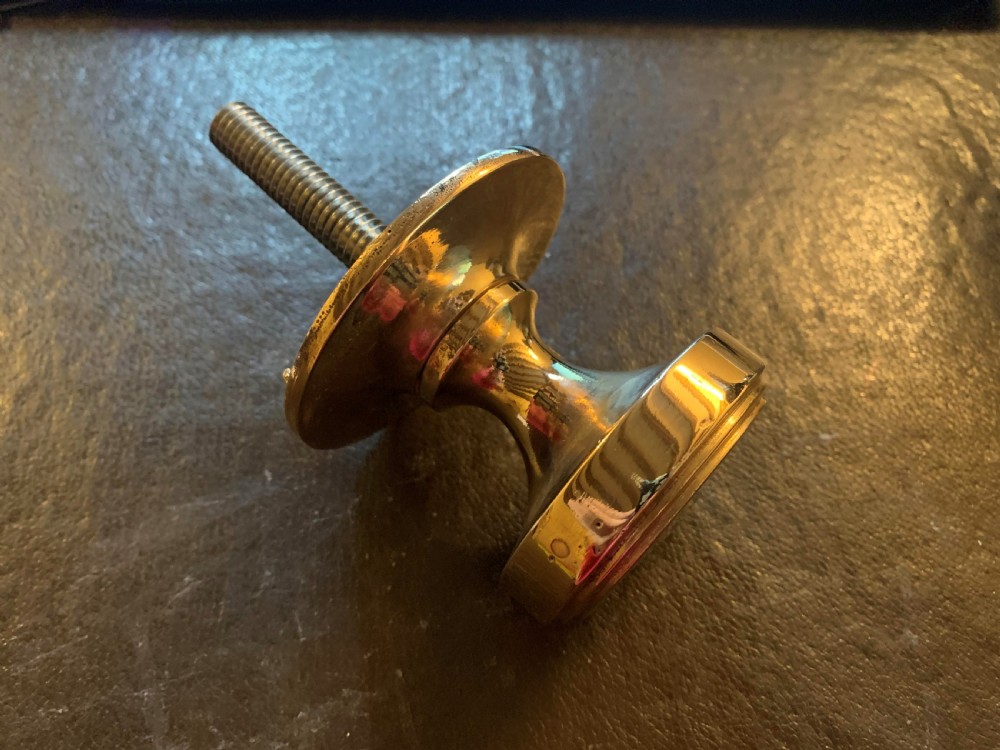 A polished bronze Edwardian centre door knob featuring a circular stepped backplate and a threaded rear fixing bolt.