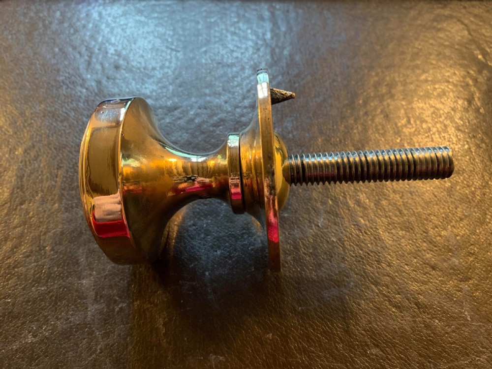 A polished bronze Edwardian centre door knob featuring a circular stepped backplate and a threaded rear fixing bolt. View II