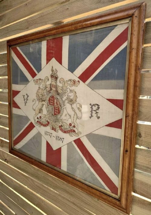 fig 1. A framed 1897 Queen Victoria Diamond Jubilee Union Jack flag featuring the Royal Coat of Arms, VR initials, and dates 1837-1897 inside a glazed wooden frame.